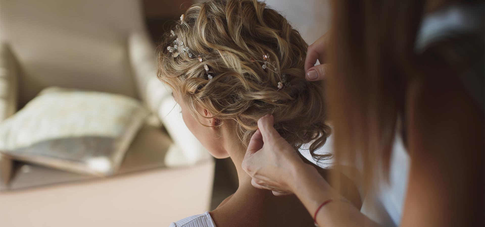 A person styling an intricate updo with hair accessories.