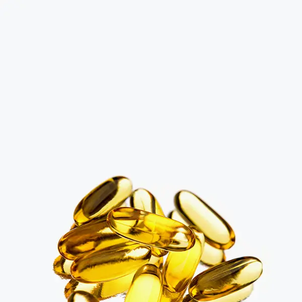 Pile of golden translucent capsules on a white background. Pile of golden translucent capsules on a white background.