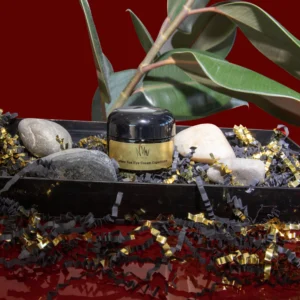 A jar of black cream on a decorative tray with stones and beads.