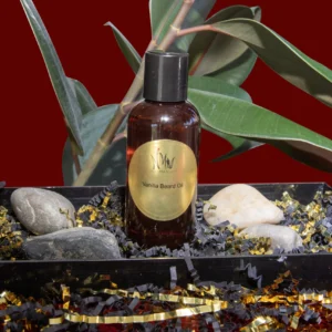 Amber-colored essential oil bottle with natural elements on red background.
