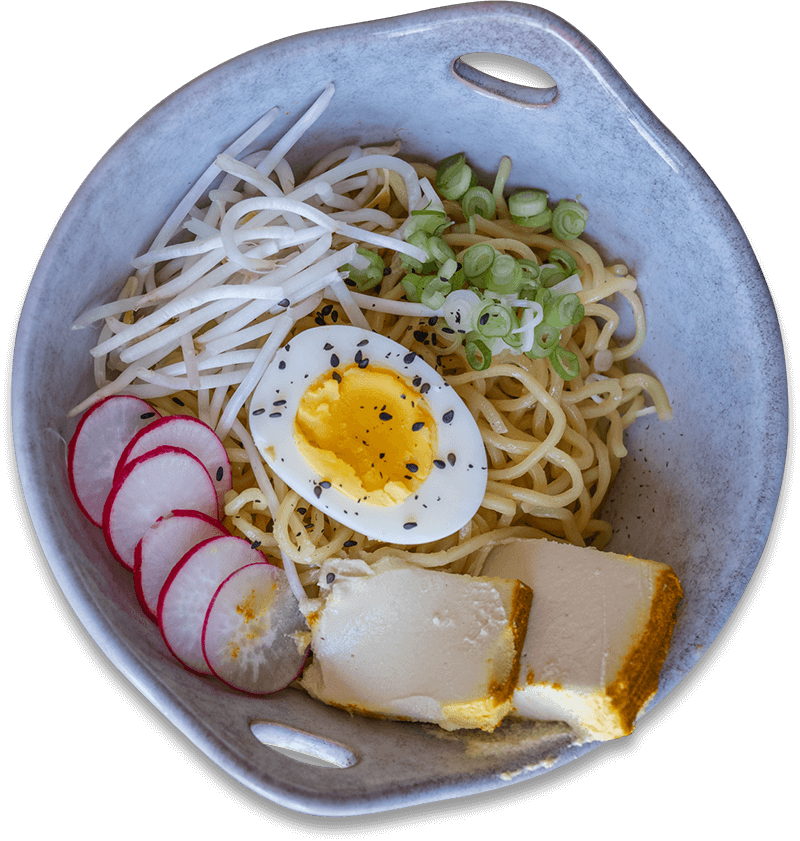 A bowl of ramen with egg, radish, noodles, and broth. A bowl of ramen with egg, radish, noodles, and broth.