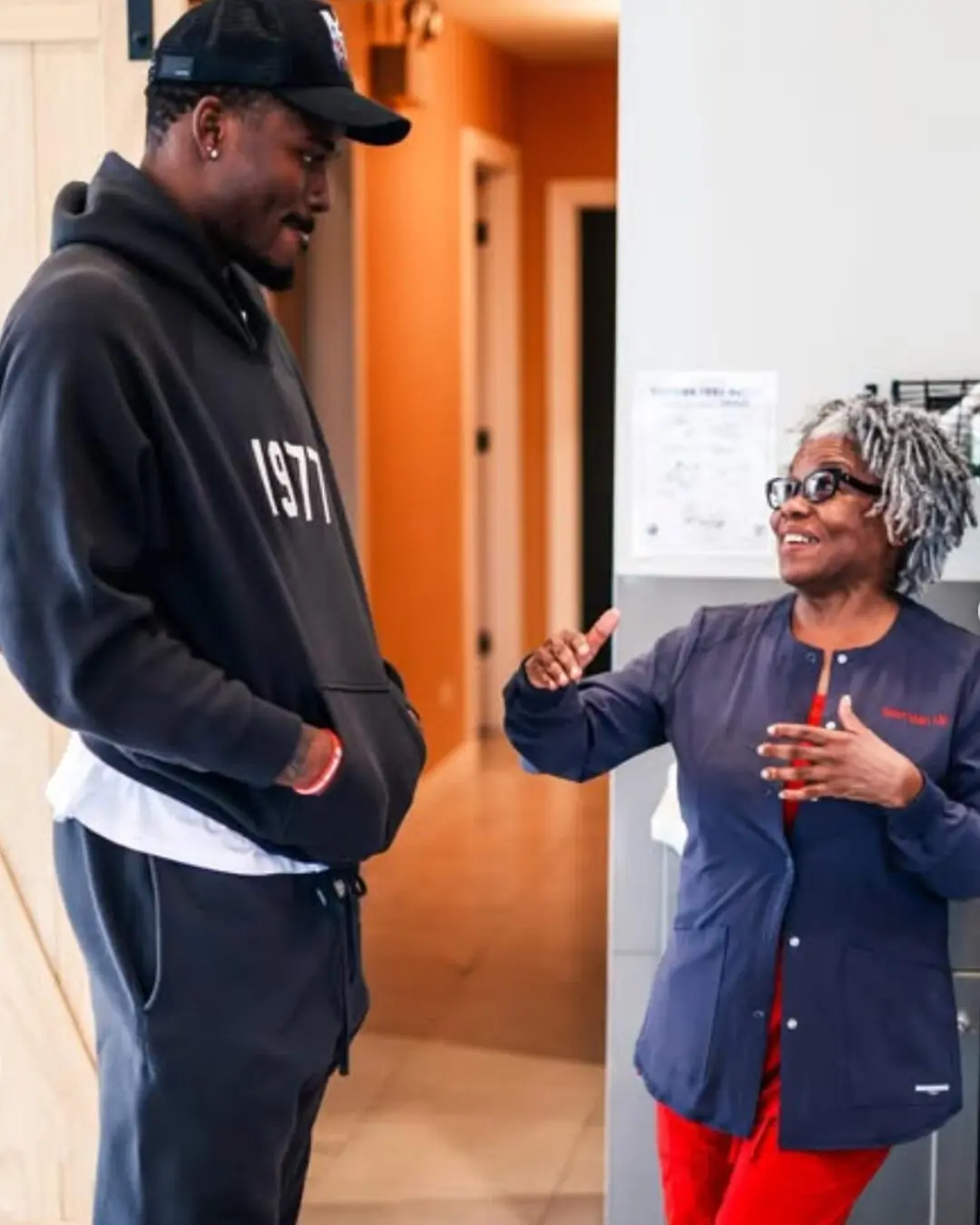 A young man and an elderly woman engaged in a warm conversation indoors. A young man and an elderly woman engaged in a warm conversation indoors.